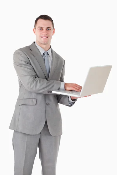 Portret van een glimlachende zakenman met een laptop werkt — Stockfoto