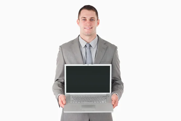 Hombre de negocios sonriente mostrando una computadora portátil — Foto de Stock