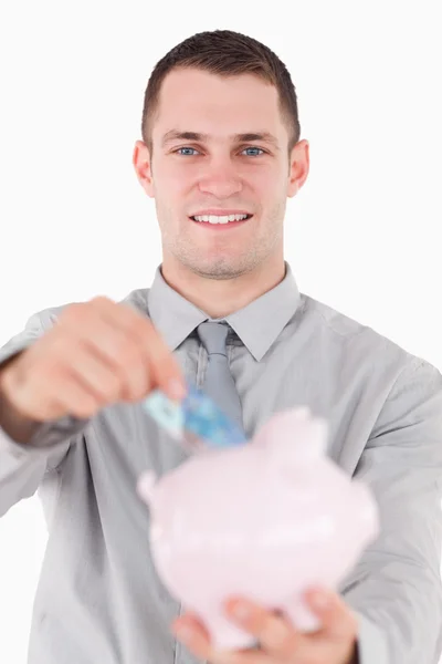 Portrait of a young businessman putting a twenty euros note in a — Stock Photo, Image