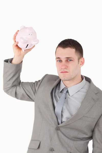Retrato de um empresário sacudindo um porquinho vazio — Fotografia de Stock