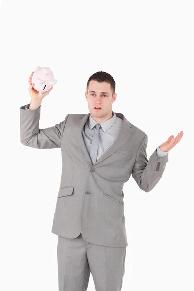Portrait of a broke businessman shaking an empty piggy bank — Stock Photo, Image