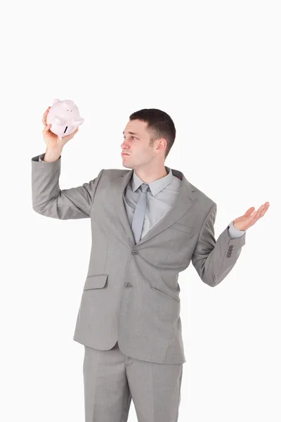 Portrait of a broke businessman looking at an empty piggy bank — Stock Photo, Image