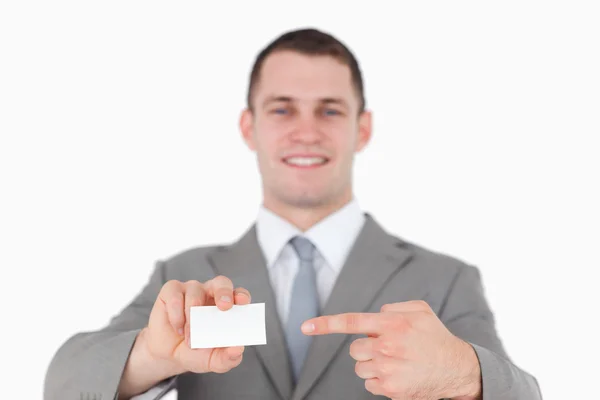 Smiling businessman pointing at a blank business card — Stock Photo, Image