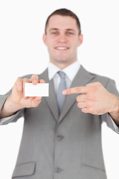 Portrait of a young businessman pointing at a blank business car — Stock Photo, Image