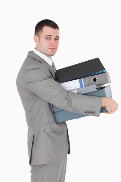 Portrait of a stressed businessman holding a stack of binders — Stock Photo, Image