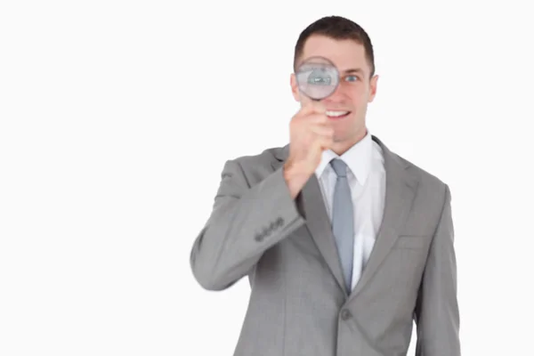 Businessman looking through a magnifying glass — Stock Photo, Image