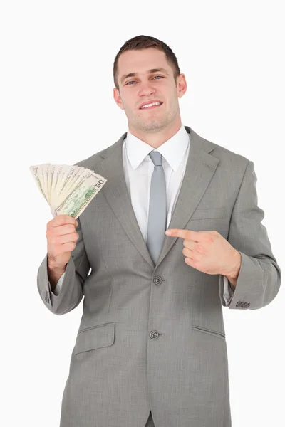 Retrato de um empresário apontando para um maço de dinheiro — Fotografia de Stock
