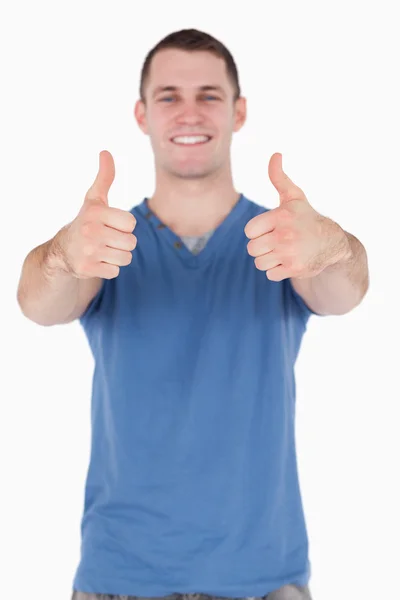 Portret van een jonge man met de duimen omhoog — Stockfoto
