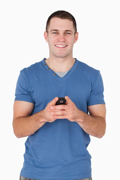 Portret mężczyzny uśmiechający się trzymając jego telefonu komórkowego — Zdjęcie stockowe