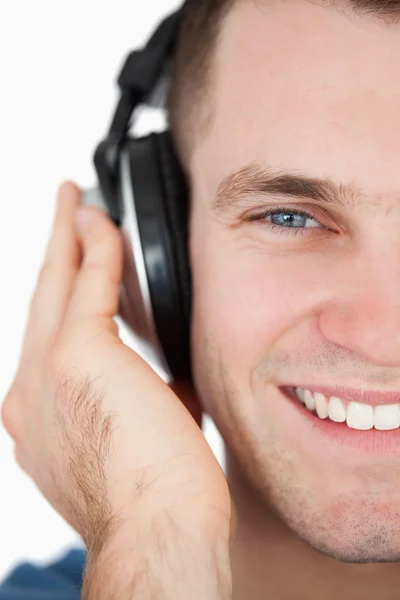 Primer plano de un hombre sonriente escuchando música — Foto de Stock