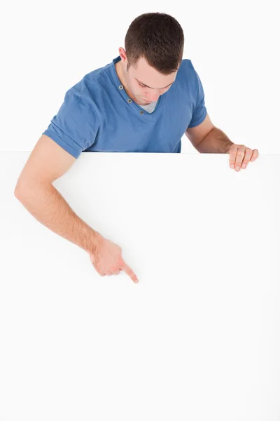 Portrait of a handsome man pointing at a blank panel — Stock Photo, Image