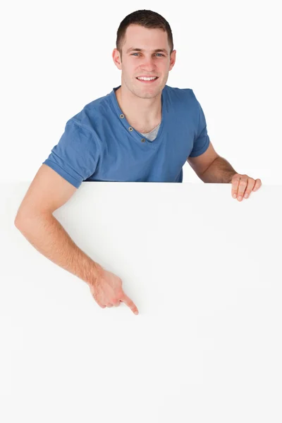 Portrét smějící se muž ukázal na prázdný panel — Stock fotografie