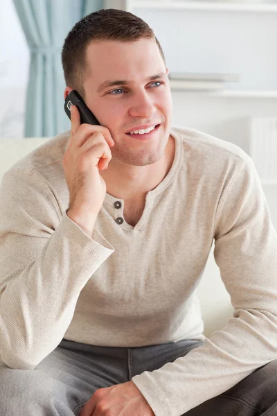 소파에 앉아있는 동안 전화 통화를 하는 남자의 초상화 — 스톡 사진