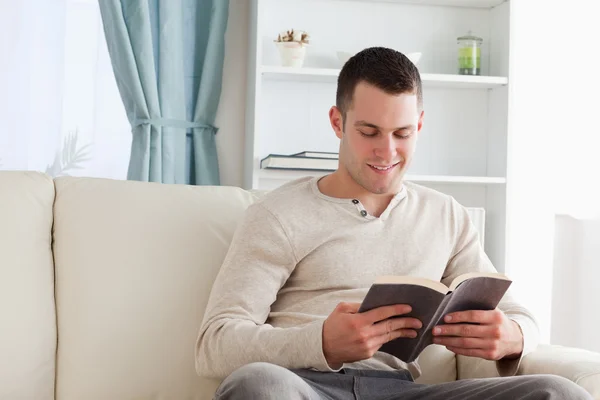 Homem bonito lendo um livro — Fotografia de Stock