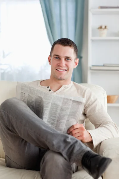 Portrait of a smiling man reading a newspaper — Stock Photo, Image