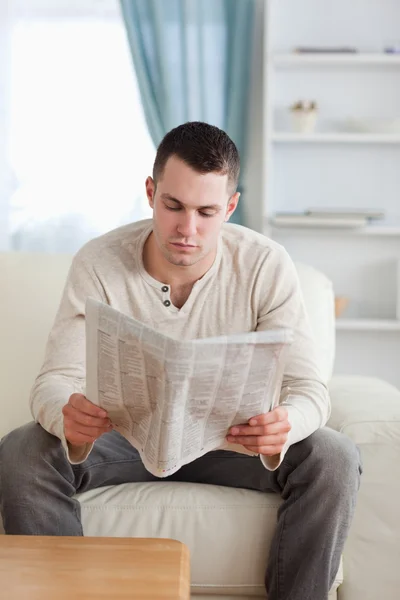 Portrét mladého muže, jak čte noviny — Stock fotografie