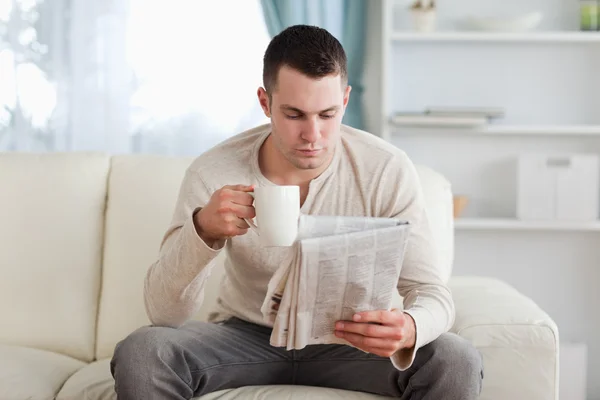 Man läsa nyheter medan du dricker en kopp kaffe — Stockfoto