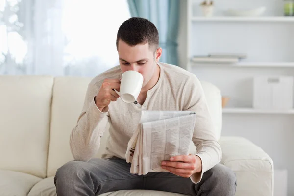 Man die leest het nieuws terwijl het drinken van een kopje thee — Stockfoto