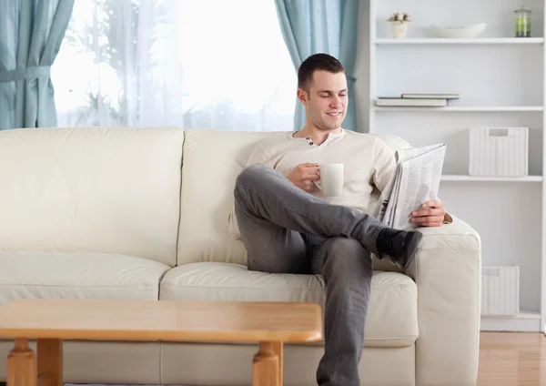 Hombre tomando un café mientras lee las noticias — Foto de Stock