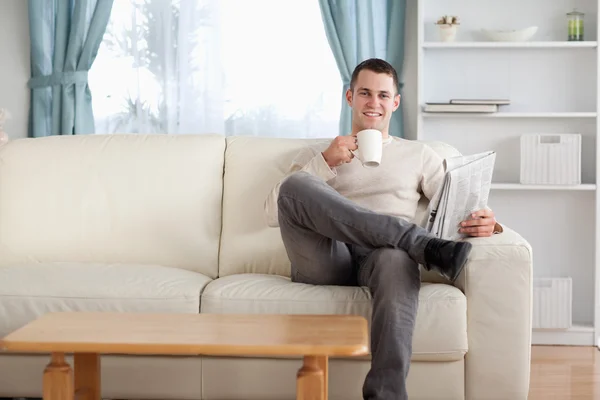Человек пьет чай, читая новости — стоковое фото