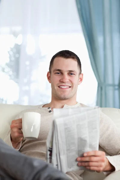 阅读新闻时喝茶的英俊男子 — ストック写真