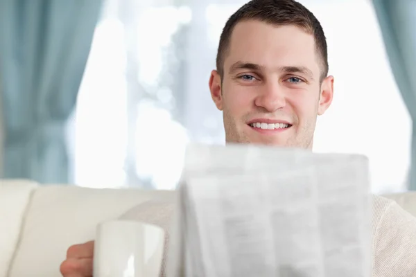 Handsome man having a coffee while reading the news — Stock Photo, Image