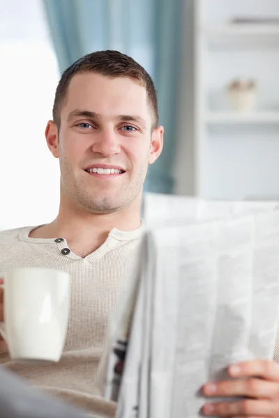 Retrato de um homem bonito tomando um café enquanto lê o novo — Fotografia de Stock