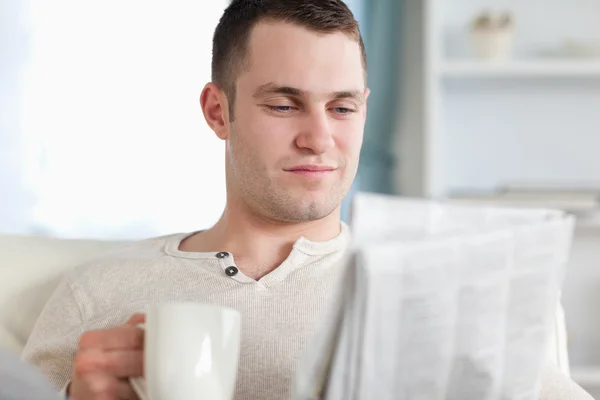 笑みを浮かべて男のニュースを読みながら、コーヒーを飲んで — ストック写真