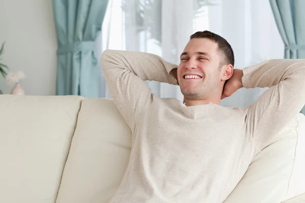 Lachender Mann entspannt sich auf einem Sofa — Stockfoto