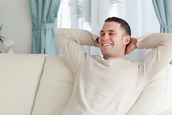 Смеющийся мужчина расслабляется на диване — стоковое фото