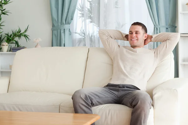 Homem feliz relaxando em um sofá — Fotografia de Stock