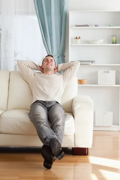 Porträt eines glücklichen Mannes, der es sich auf einer Couch gemütlich macht — Stockfoto