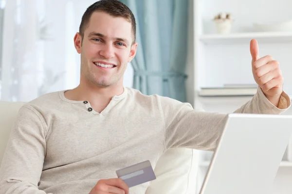Sorrindo homem compras on-line com o polegar para cima — Fotografia de Stock