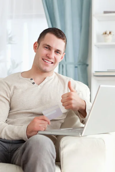 Portrait of a man shopping online with the thumb up — Stock Photo, Image