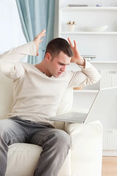 Portrait of an unhappy man using a laptop — Stock Photo, Image