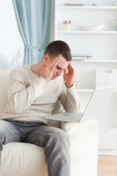 Bir dizüstü bilgisayar kullanarak yorgun bir adam portresi — Stok fotoğraf