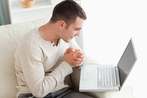 Genç adam bir dizüstü bilgisayar kullanarak — Stok fotoğraf