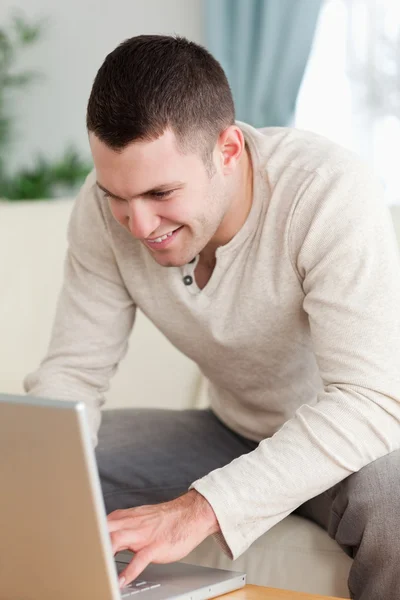 Porträtt av en leende man använder en bärbar dator — Stockfoto