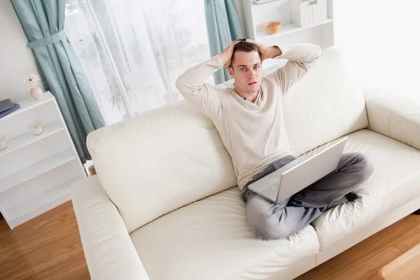 Sad man relaxing with a notebook — Stock Photo, Image