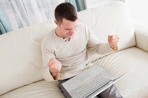 Victorious man using a laptop — Stock Photo, Image