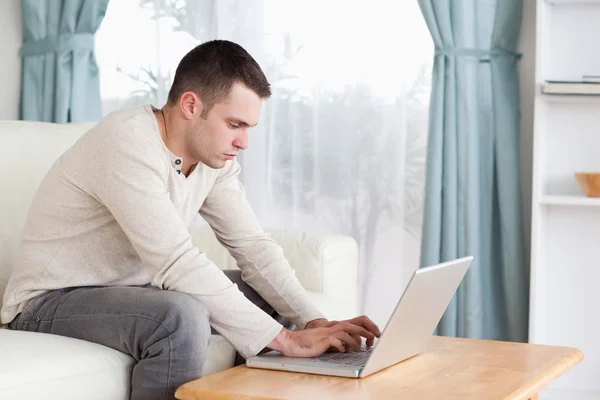 Genç adam onun dizüstü bilgisayarda yazarak — Stok fotoğraf