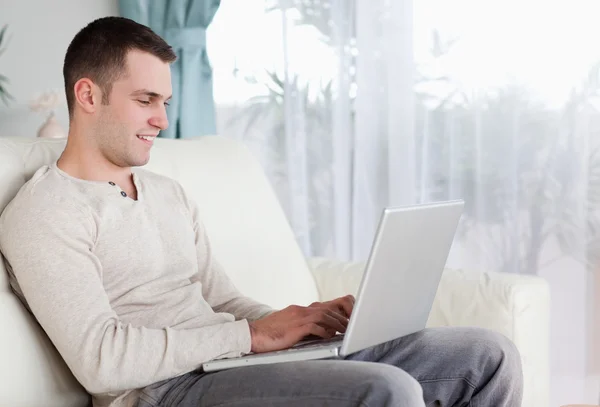 Szczęśliwy człowiek, wpisując na swoim laptopie — Zdjęcie stockowe