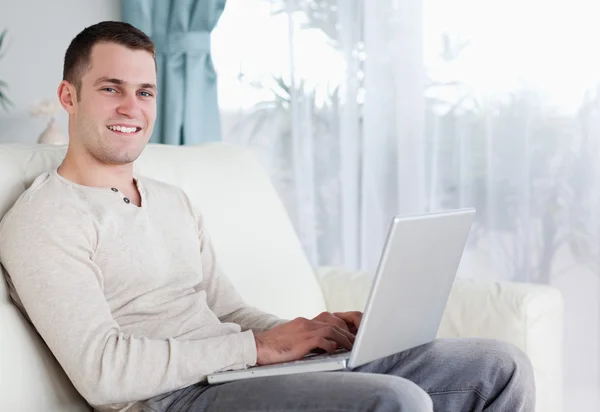 Щасливий чоловік набирає на свій ноутбук — стокове фото