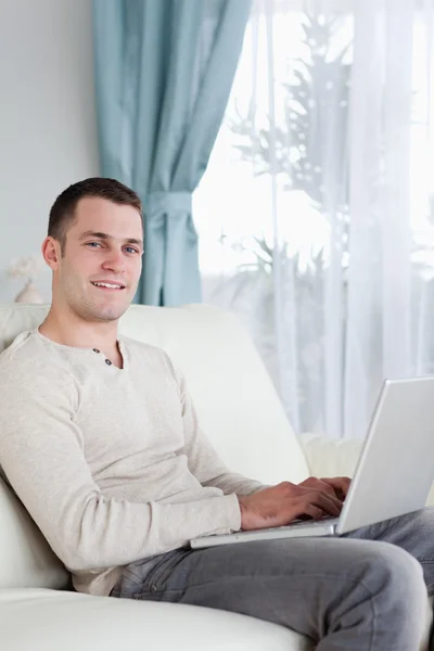 Πορτρέτο του ένα ευτυχισμένο άνθρωπο που πληκτρολογείτε για το φορητό υπολογιστή — Φωτογραφία Αρχείου