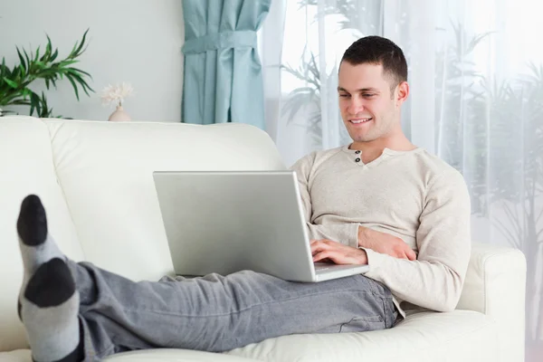 Sorrindo homem trabalhando com seu laptop — Fotografia de Stock