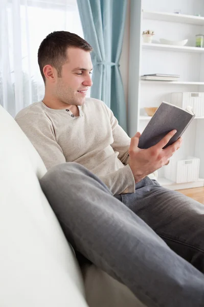 Porträtt av en leende man läser en bok — Stockfoto