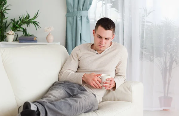 Sad man holding a cup of coffee — Stock Photo, Image