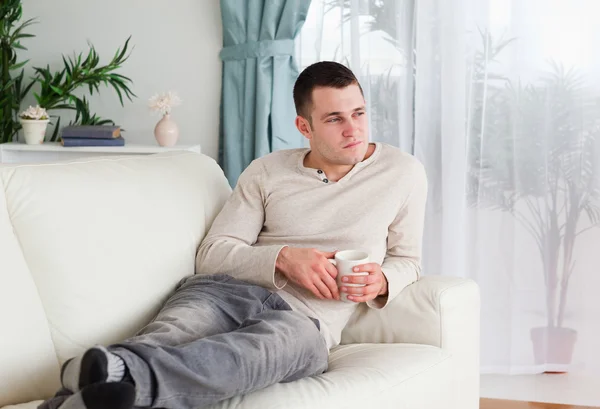 Pensive man holding a cup of coffee — Stock Photo, Image
