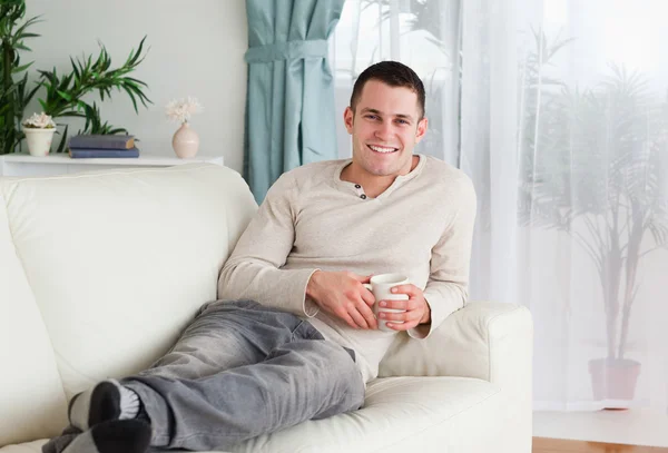 Hombre sonriente sosteniendo una taza de café —  Fotos de Stock