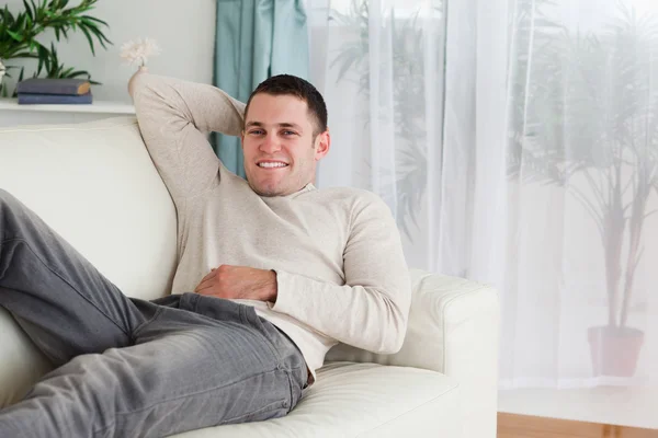 Mannen som ligger på en soffa — Stockfoto